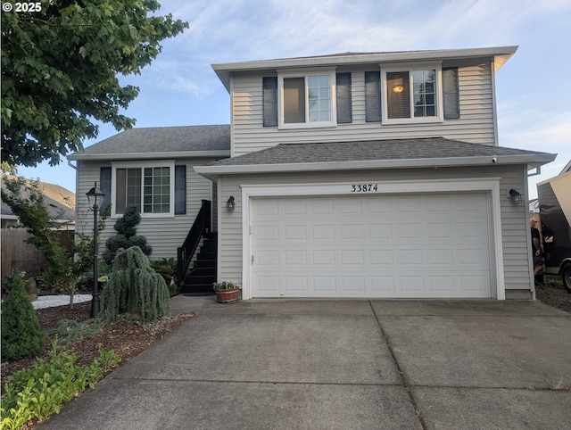 33874 NE Erin Dr, Scappoose, OR 97056 - tri-level home featuring a garage, driveway, and stairs