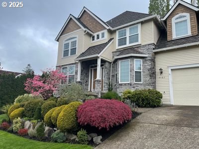 9587 NW Caxton Ln, Portland, OR 97229 - craftsman-style house featuring stone siding, a garage, and driveway