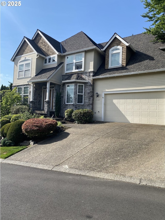 9587 NW Caxton Ln, Portland, OR 97229 - craftsman-style home with driveway, stone siding, a garage, and a shingled roof