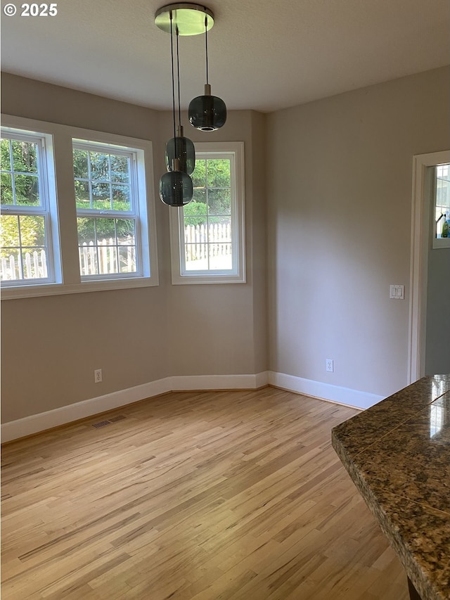 9587 NW Caxton Ln, Portland, OR 97229 - unfurnished dining area featuring light wood-style flooring and baseboards