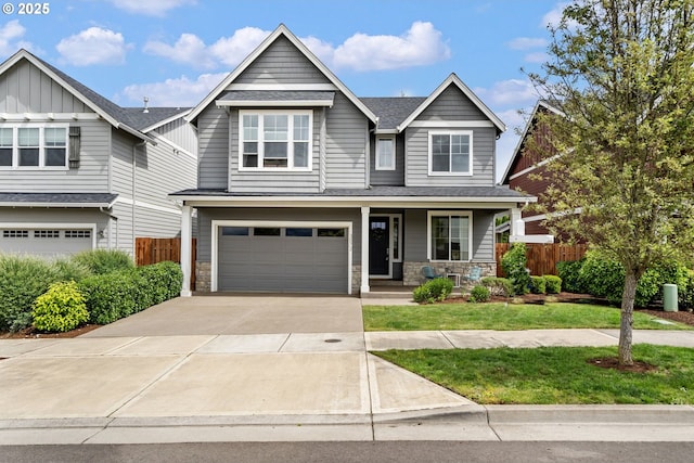 view of front of house with a porch, concrete driveway, stone siding, and a garage