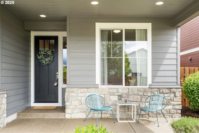 property entrance featuring stone siding and a porch