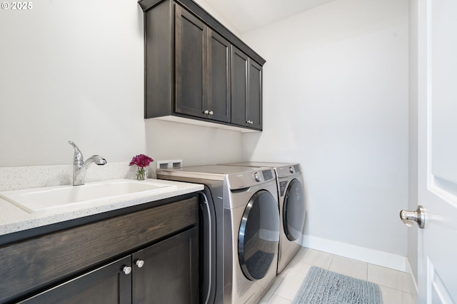 clothes washing area featuring cabinet space, washer and dryer, light tile patterned flooring, and baseboards