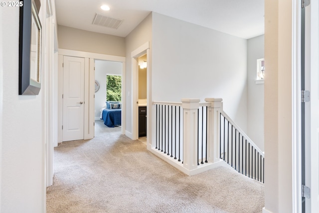 hallway featuring an upstairs landing and carpet flooring