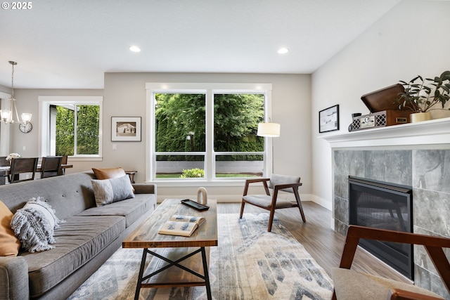 living area with wood finished floors, a fireplace, recessed lighting, a chandelier, and baseboards