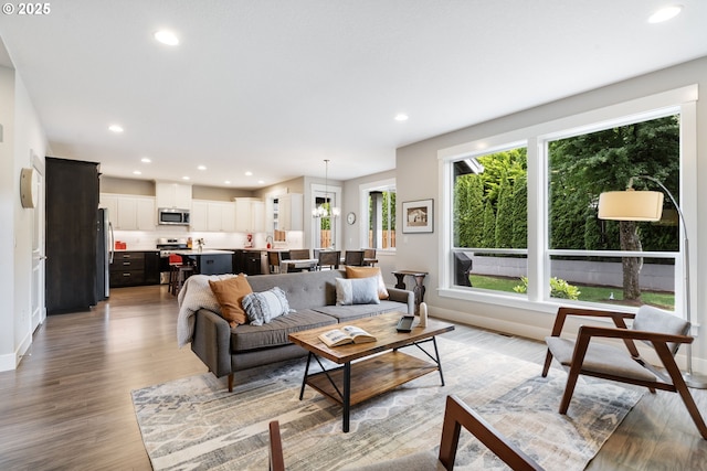 living area featuring light wood-style floors, recessed lighting, and baseboards