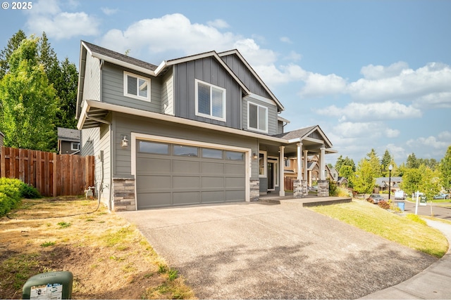 3100 NE 171st St, Ridgefield, WA 98642 - view of front of property with board and batten siding, covered porch, an attached garage, stone siding, and concrete driveway