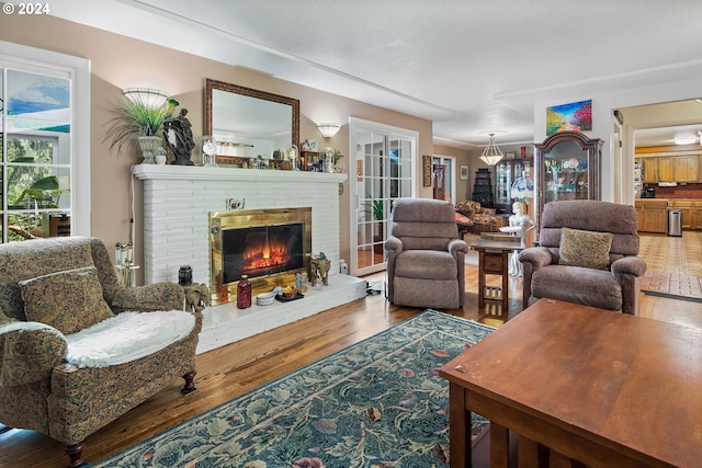 living area with a brick fireplace and wood finished floors