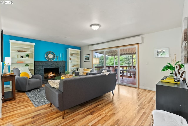 7005 SW 14th Ave, Portland, OR 97219 - living area featuring built in features, light wood-type flooring, a stone fireplace, and baseboards