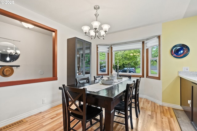 7005 SW 14th Ave, Portland, OR 97219 - dining space featuring a chandelier, light wood-type flooring, and baseboards