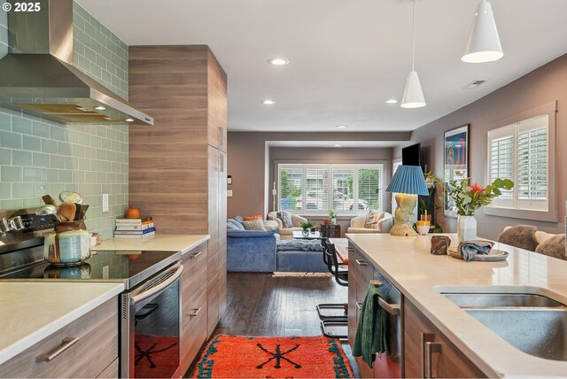 7913 SE Henderson St, Portland, OR 97206 - kitchen with stainless steel electric range oven, wall chimney exhaust hood, dark wood-style floors, light countertops, and decorative backsplash