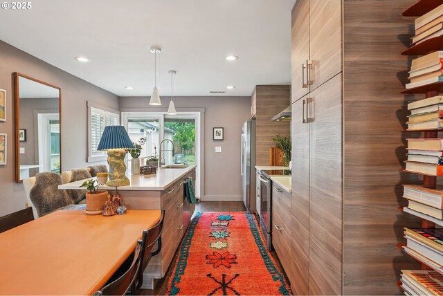7913 SE Henderson St, Portland, OR 97206 - kitchen with modern cabinets, stainless steel appliances, light countertops, recessed lighting, and pendant lighting