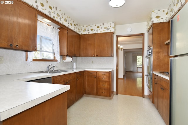 kitchen featuring stainless steel appliances, sink, and backsplash