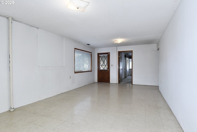 unfurnished room featuring a textured ceiling