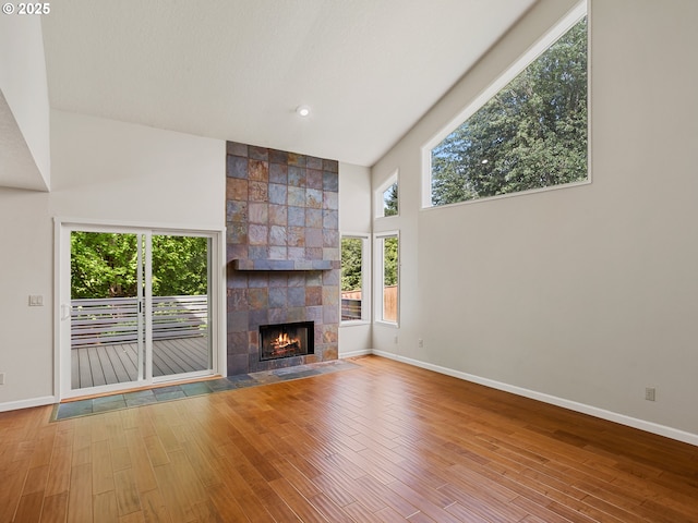 15917 NE Union Rd Unit 103, Ridgefield, WA 98642 - unfurnished living room featuring wood finished floors, high vaulted ceiling, and a tile fireplace