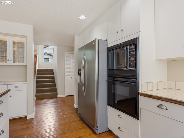 15917 NE Union Rd Unit 103, Ridgefield, WA 98642 - kitchen featuring black appliances, tile countertops, white cabinetry, wood finished floors, and recessed lighting