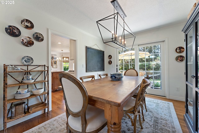 20525 Martin Ct, West Linn, OR 97068 - dining space with a chandelier, a textured ceiling, healthy amount of natural light, ornamental molding, and wood finished floors
