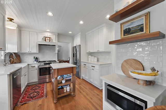 20525 Martin Ct, West Linn, OR 97068 - kitchen featuring appliances with stainless steel finishes, open shelves, recessed lighting, light wood-style flooring, and tasteful backsplash