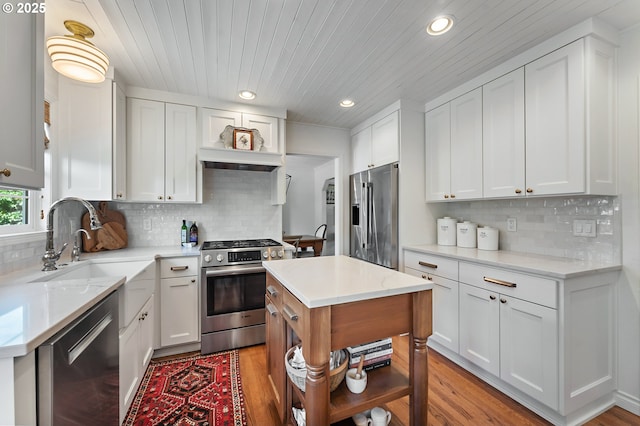 20525 Martin Ct, West Linn, OR 97068 - kitchen featuring appliances with stainless steel finishes, white cabinetry, recessed lighting, tasteful backsplash, and light wood-style floors