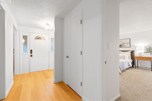 foyer entrance with wood-type flooring and a textured ceiling