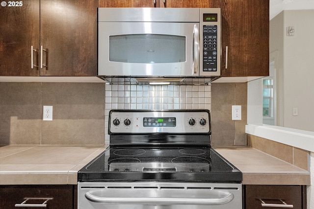 630 NE Adwick Dr, Hillsboro, OR 97006 - kitchen with appliances with stainless steel finishes, dark brown cabinetry, light countertops, and tasteful backsplash
