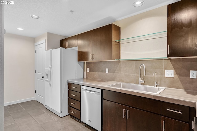 630 NE Adwick Dr, Hillsboro, OR 97006 - kitchen with stainless steel dishwasher, a sink, white fridge with ice dispenser, decorative backsplash, and dark brown cabinets