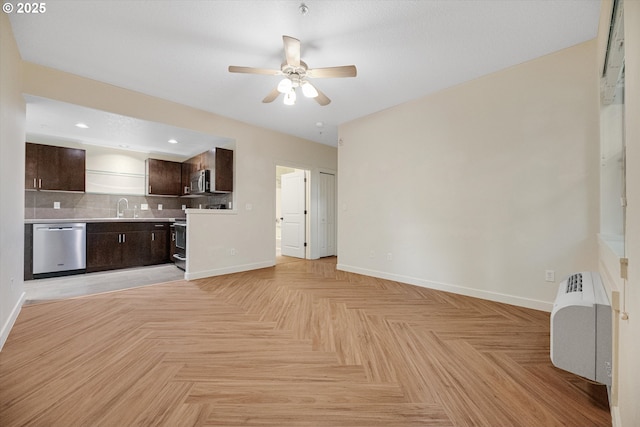 630 NE Adwick Dr, Hillsboro, OR 97006 - kitchen with stainless steel appliances, baseboards, a sink, dark brown cabinetry, and light countertops
