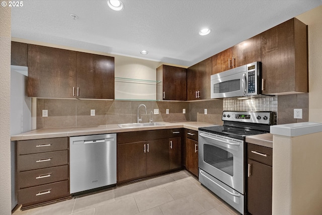 630 NE Adwick Dr, Hillsboro, OR 97006 - kitchen featuring appliances with stainless steel finishes, a sink, decorative backsplash, light countertops, and dark brown cabinets