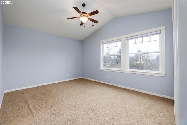 empty room featuring lofted ceiling, carpet floors, and ceiling fan