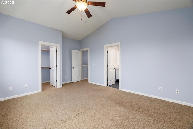 unfurnished bedroom with ensuite bathroom, carpet floors, a spacious closet, vaulted ceiling, and a closet