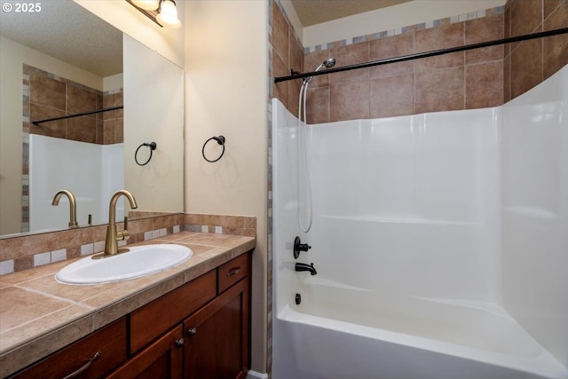 bathroom with vanity, shower / bathtub combination, and a textured ceiling