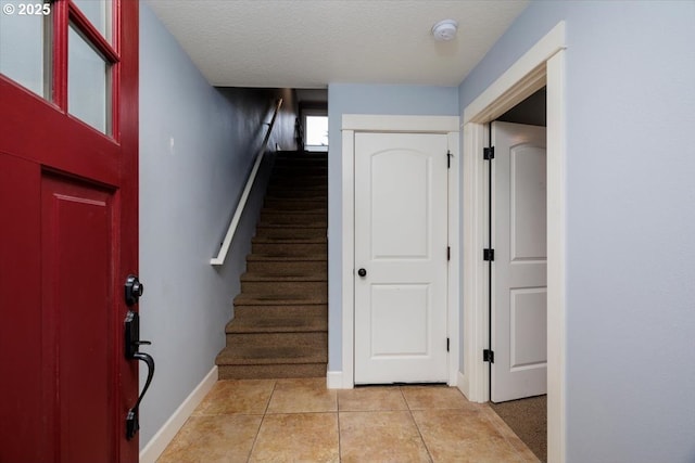 staircase featuring tile patterned floors and a textured ceiling