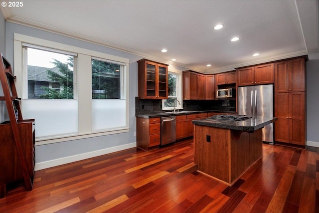 kitchen with crown molding, stainless steel appliances, a kitchen breakfast bar, a kitchen island, and dark hardwood / wood-style flooring