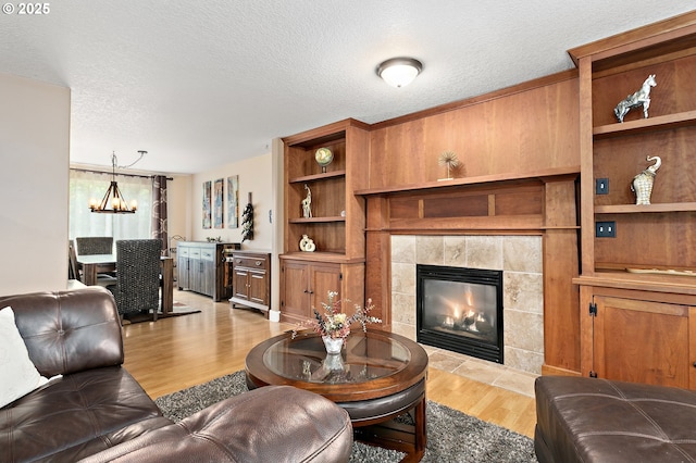 16506 NE 13th St, Vancouver, WA 98684 - living area featuring light wood-type flooring, a tile fireplace, a chandelier, and a textured ceiling