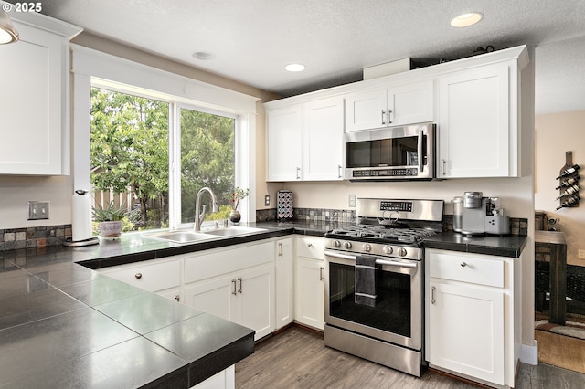 16506 NE 13th St, Vancouver, WA 98684 - kitchen with appliances with stainless steel finishes, white cabinetry, dark countertops, recessed lighting, and wood finished floors