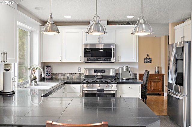 16506 NE 13th St, Vancouver, WA 98684 - kitchen with stainless steel appliances, white cabinets, dark countertops, decorative light fixtures, and recessed lighting