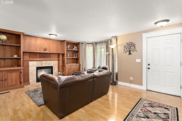 16506 NE 13th St, Vancouver, WA 98684 - living area featuring a textured ceiling, a fireplace, and light wood-style floors