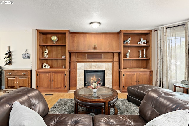 16506 NE 13th St, Vancouver, WA 98684 - living room with light wood finished floors, a tile fireplace, and a textured ceiling