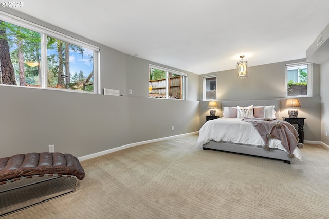 carpeted bedroom featuring multiple windows, visible vents, and baseboards