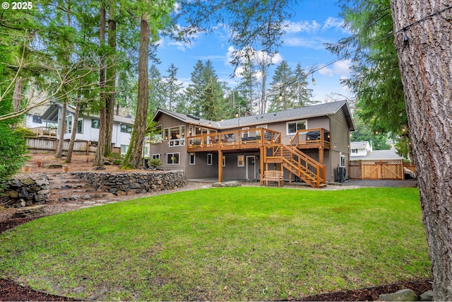 rear view of house featuring fence, a wooden deck, stairs, a lawn, and a gate