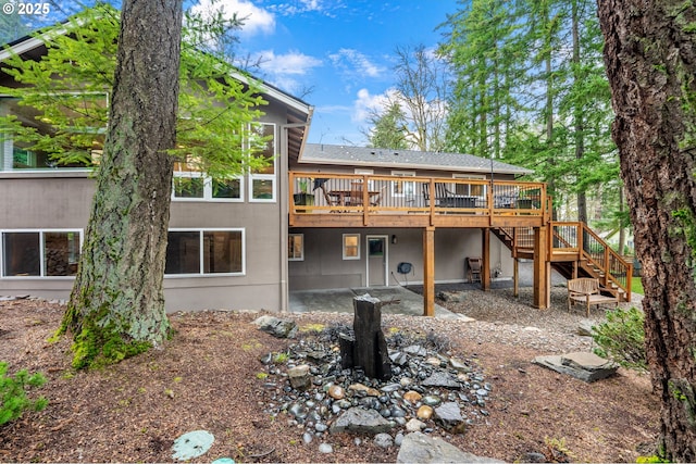 rear view of property with stairway and a wooden deck