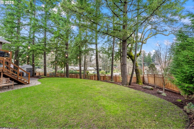 view of yard with a storage shed, an outdoor structure, stairs, and a fenced backyard