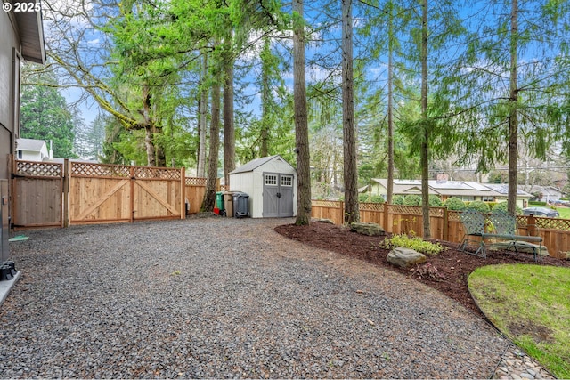 view of yard featuring an outdoor structure, a gate, fence, and a shed