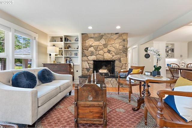 living room featuring dark wood finished floors, a stone fireplace, and recessed lighting