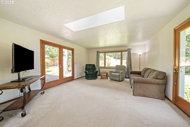 16390 SE Hillside Ln, Milwaukie, OR 97267 - carpeted living area with a textured ceiling, a skylight, french doors, and healthy amount of natural light