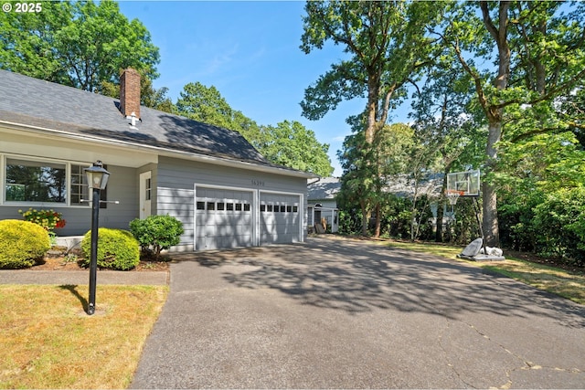 16390 SE Hillside Ln, Milwaukie, OR 97267 - view of side of property with asphalt driveway, a chimney, and an attached garage