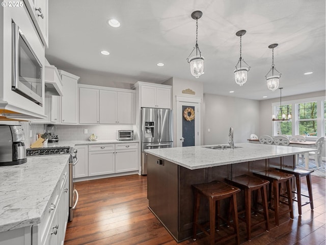 kitchen featuring backsplash, appliances with stainless steel finishes, white cabinets, and dark wood-style flooring