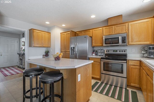 1227 Trent Ave, Keizer, OR 97303 - kitchen with appliances with stainless steel finishes, a center island, a kitchen breakfast bar, light countertops, and recessed lighting