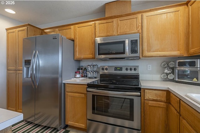 1227 Trent Ave, Keizer, OR 97303 - kitchen featuring appliances with stainless steel finishes, light countertops, brown cabinets, and recessed lighting