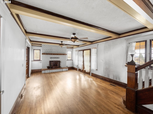 unfurnished living room featuring hardwood / wood-style flooring, ceiling fan, crown molding, and beam ceiling